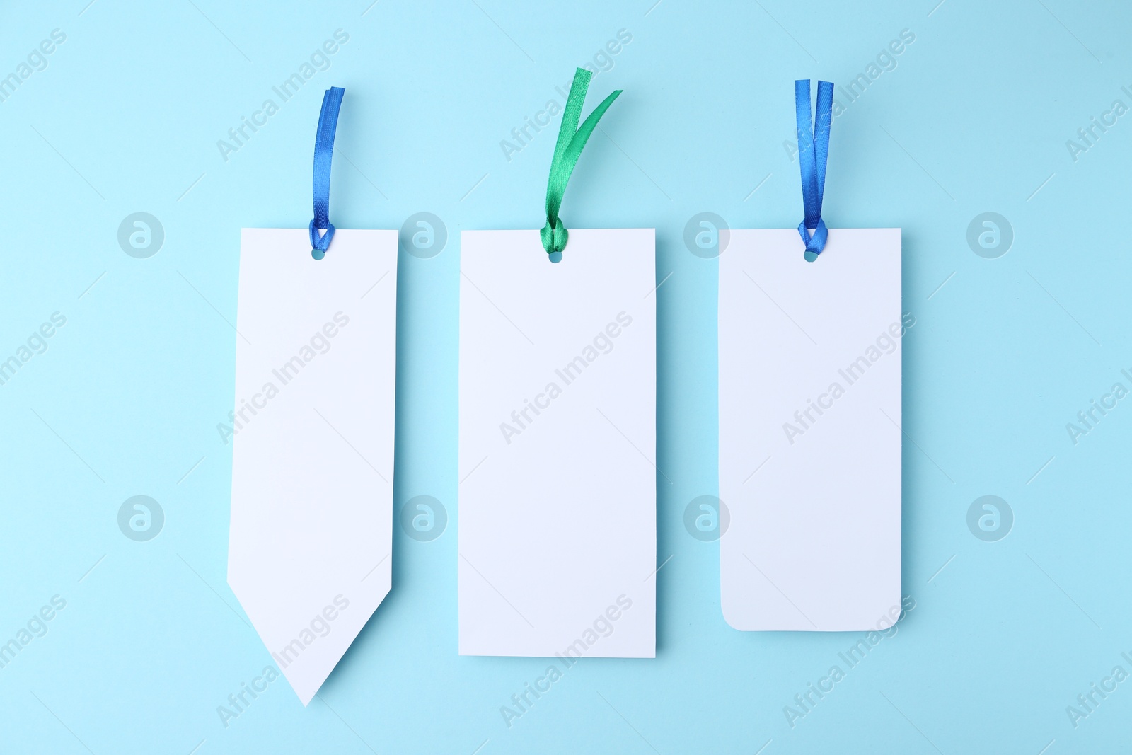 Photo of Paper bookmarks on light blue background, top view