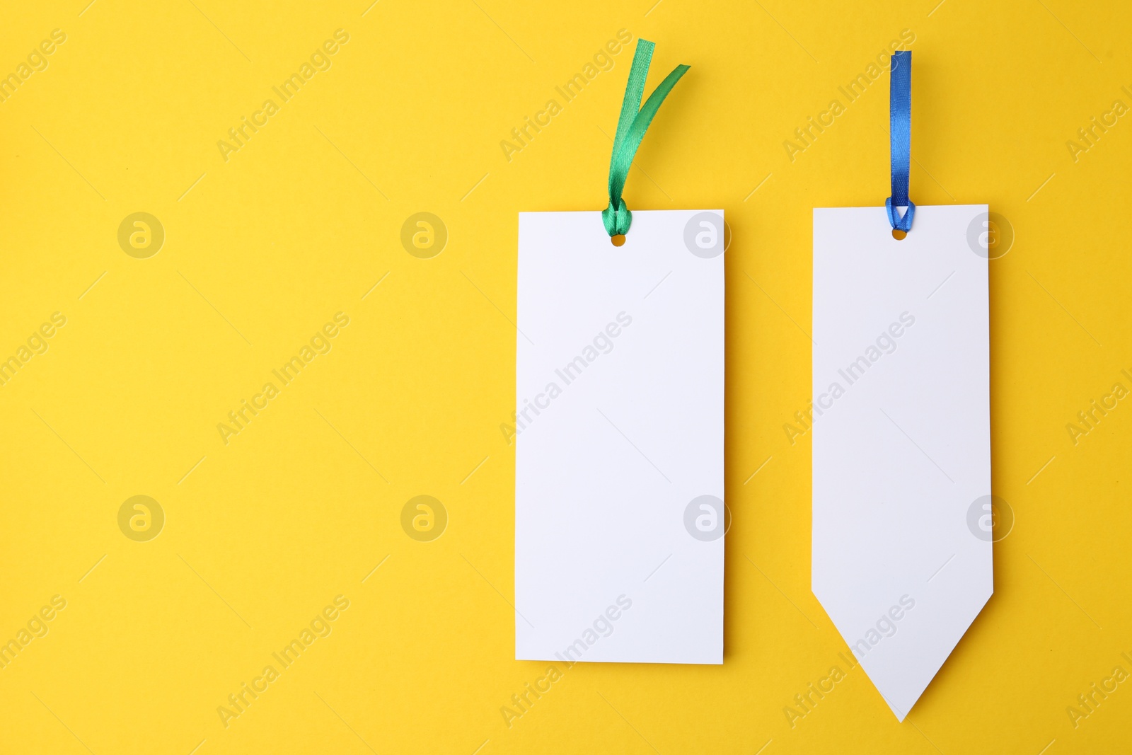 Photo of Paper bookmarks on yellow background, top view. Space for text