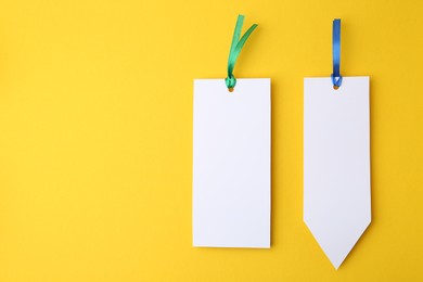 Photo of Paper bookmarks on yellow background, top view. Space for text