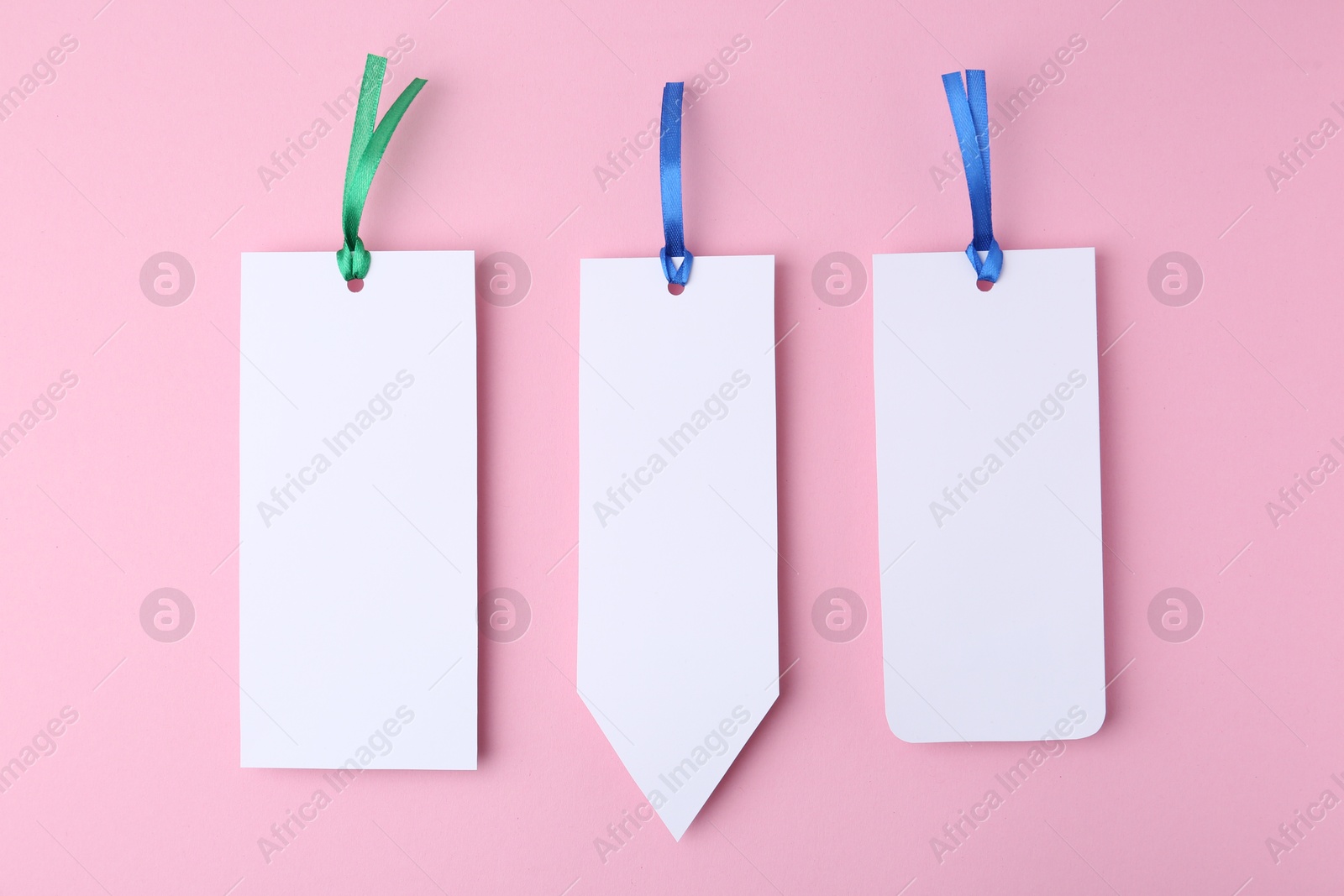 Photo of Paper bookmarks on pink background, top view