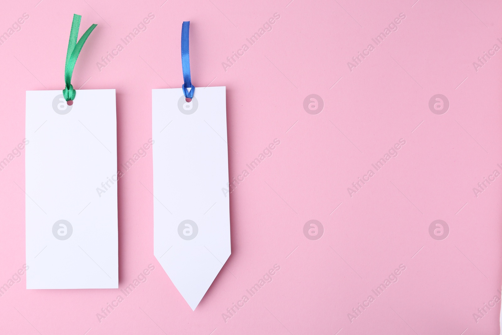 Photo of Paper bookmarks on pink background, top view. Space for text