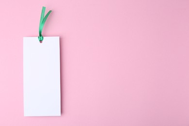 Photo of One paper bookmark on pink background, top view. Space for text