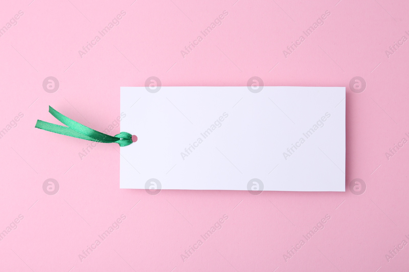 Photo of One paper bookmark on pink background, top view