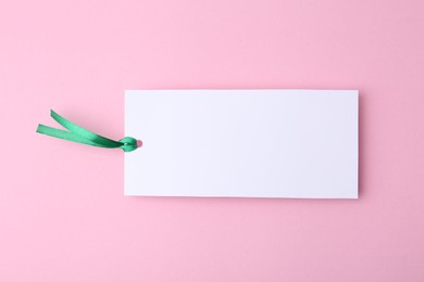 Photo of One paper bookmark on pink background, top view