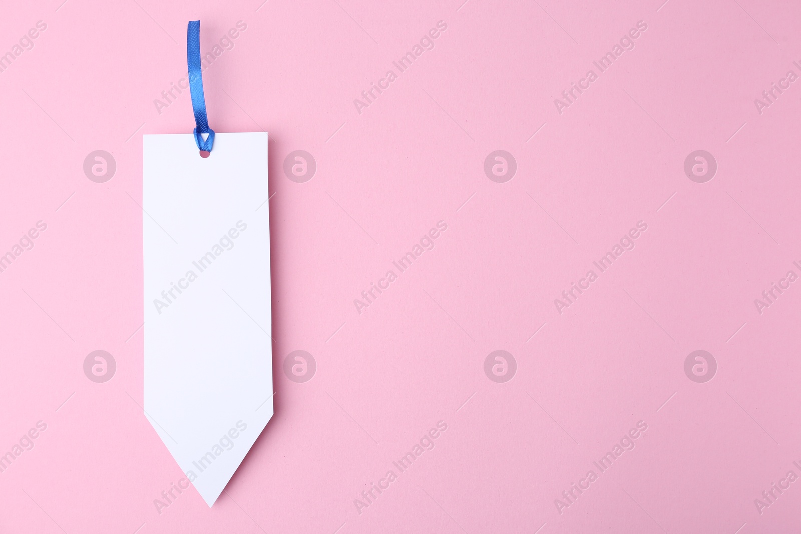 Photo of One paper bookmark on pink background, top view. Space for text