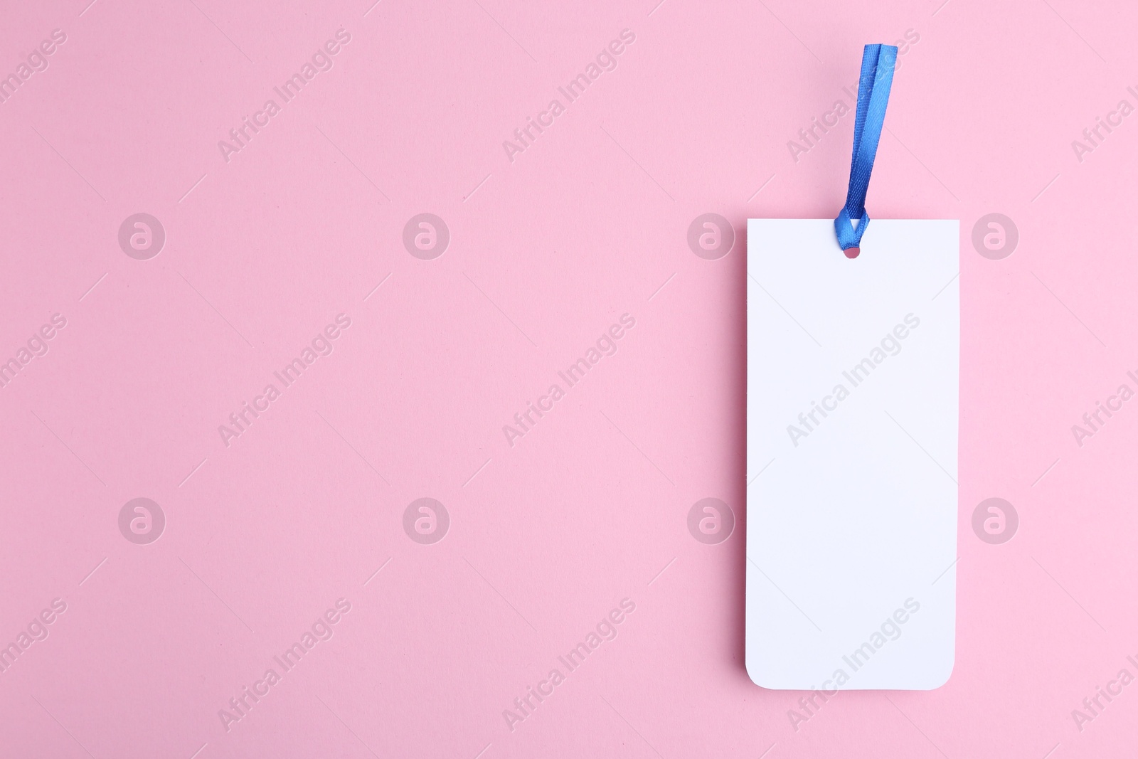 Photo of One paper bookmark on pink background, top view. Space for text