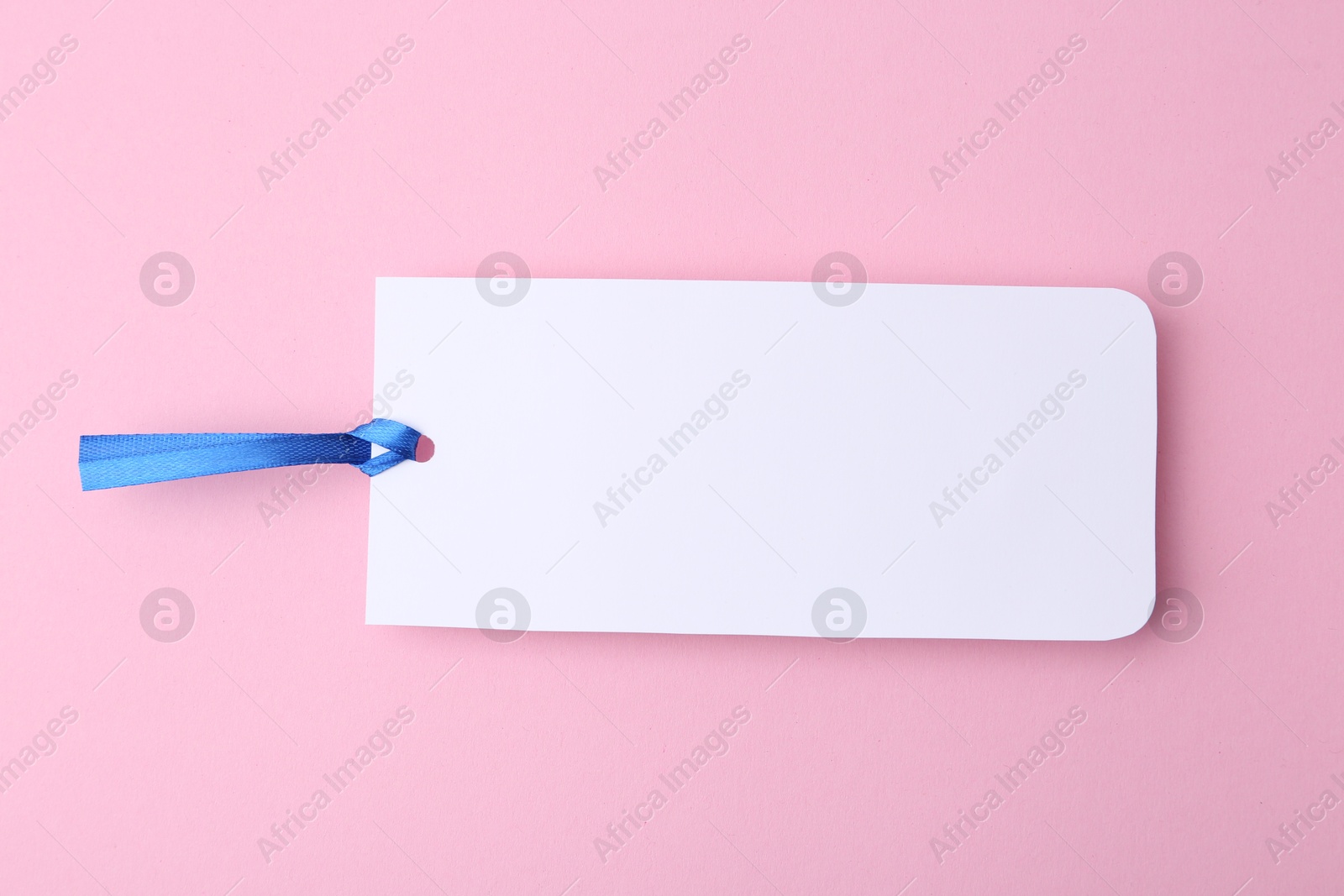 Photo of One paper bookmark on pink background, top view