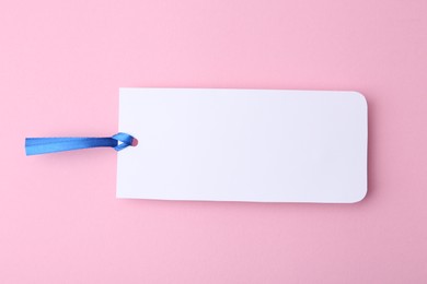 Photo of One paper bookmark on pink background, top view