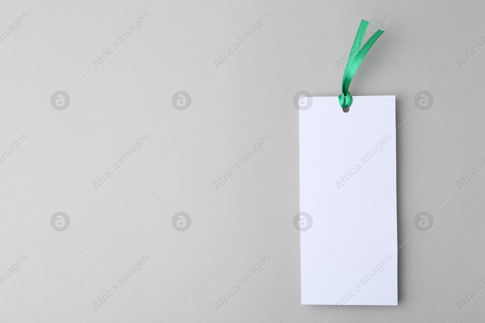 Photo of One paper bookmark on light grey background, top view. Space for text