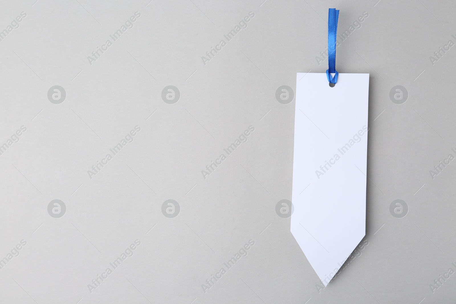 Photo of One paper bookmark on light grey background, top view. Space for text