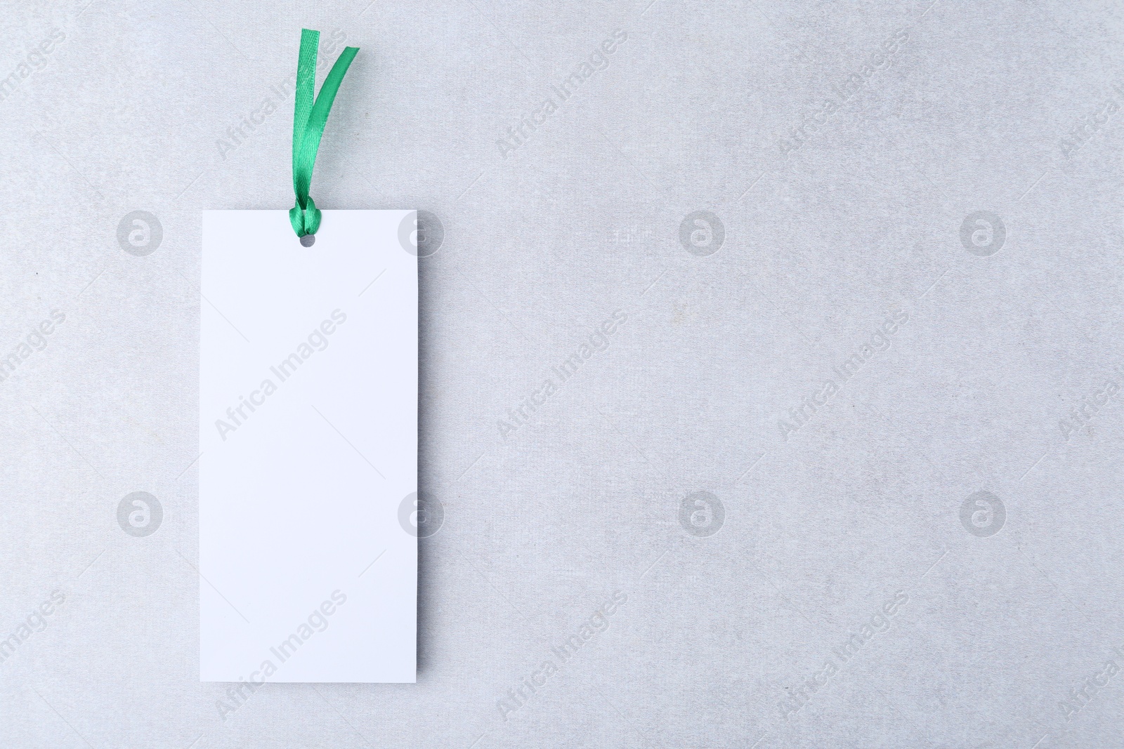 Photo of One paper bookmark on light grey background, top view. Space for text