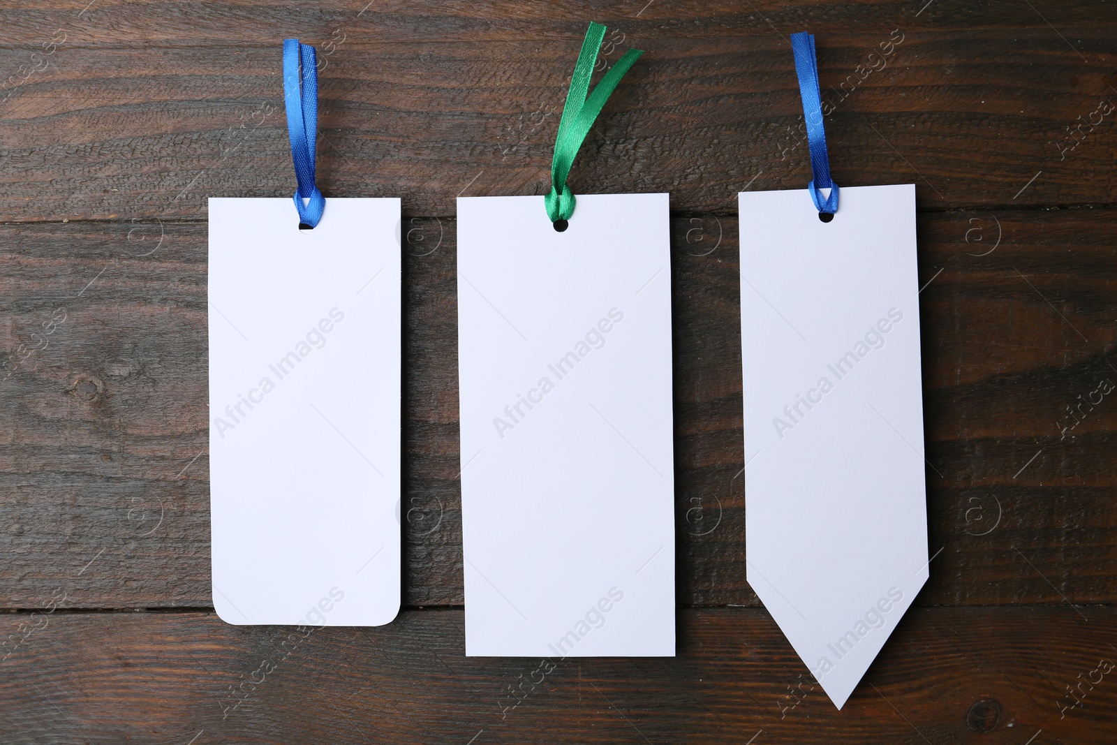 Photo of Paper bookmarks on wooden background, top view