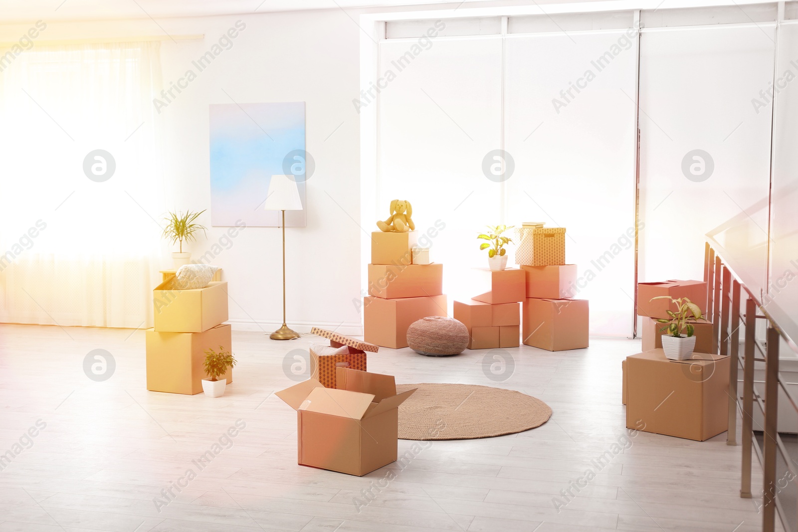 Image of Sunlit room with cardboard boxes. Moving day