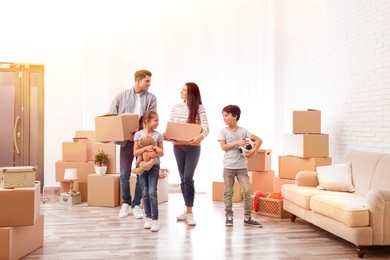 Image of Happy family in sunlit room with cardboard boxes on moving day