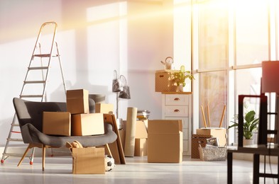 Image of Sunlit room with cardboard boxes. Moving day