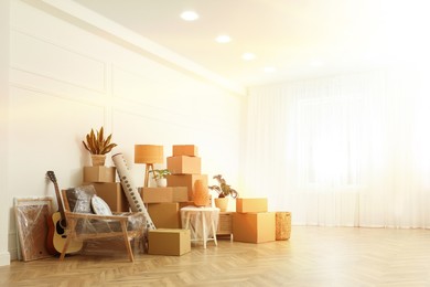 Image of Sunlit room with cardboard boxes. Moving day