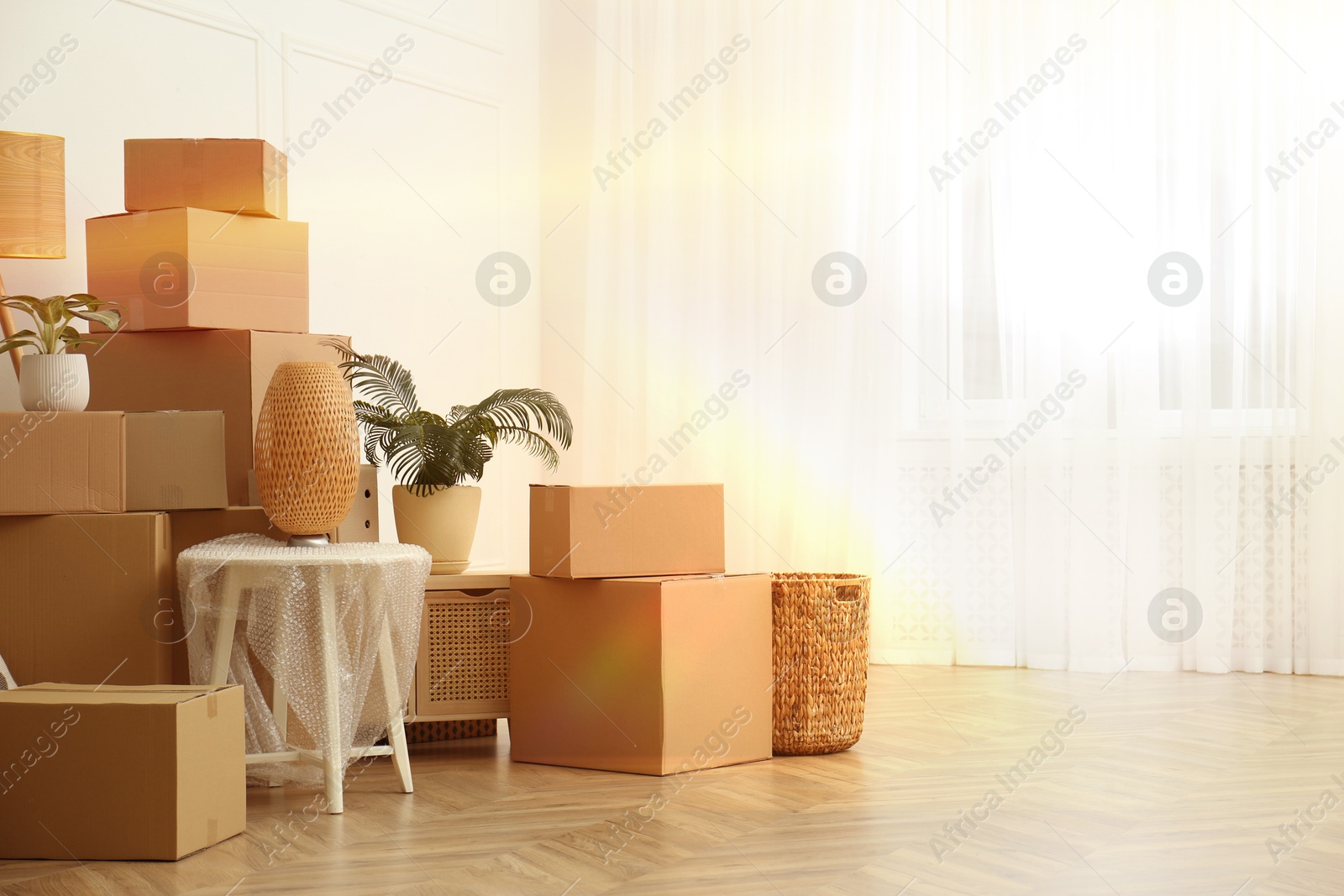 Image of Sunlit room with cardboard boxes. Moving day