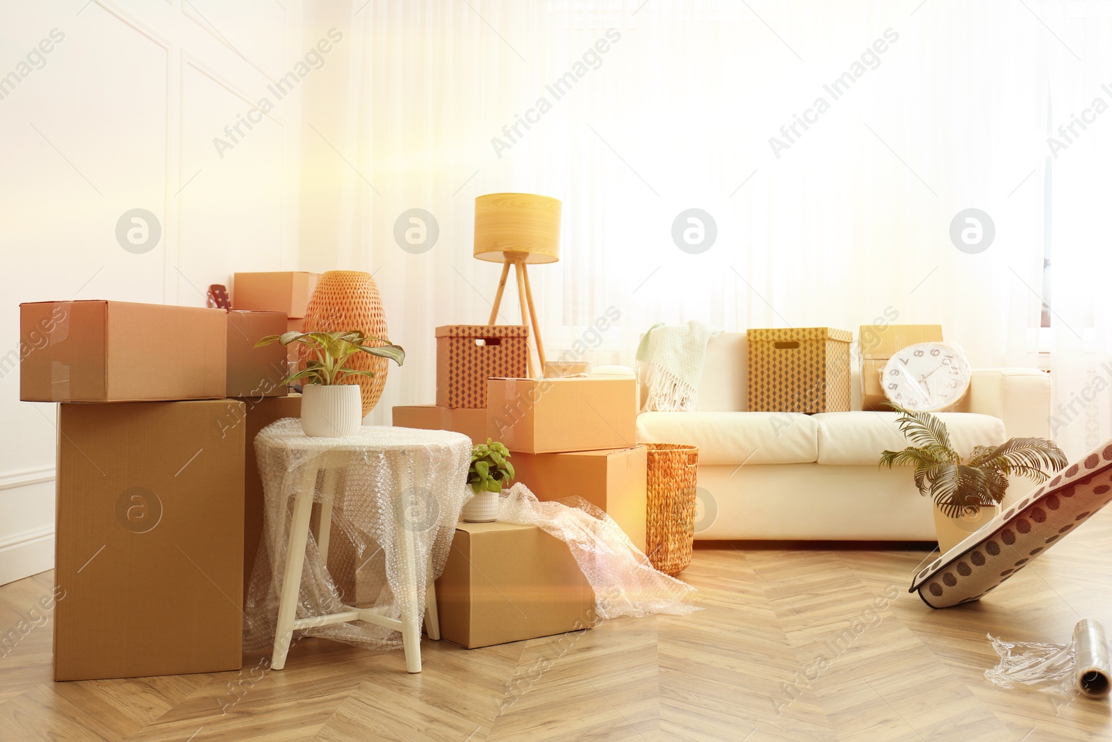 Image of Sunlit room with cardboard boxes. Moving day