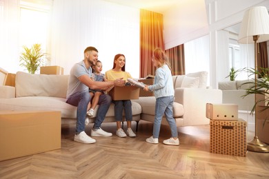 Image of Happy family in sunlit room with cardboard boxes on moving day