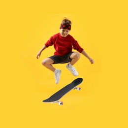 Image of Cute little boy with skateboard in air on yellow background. Performing trick