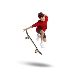 Cute little boy with skateboard in air on white background. Performing trick