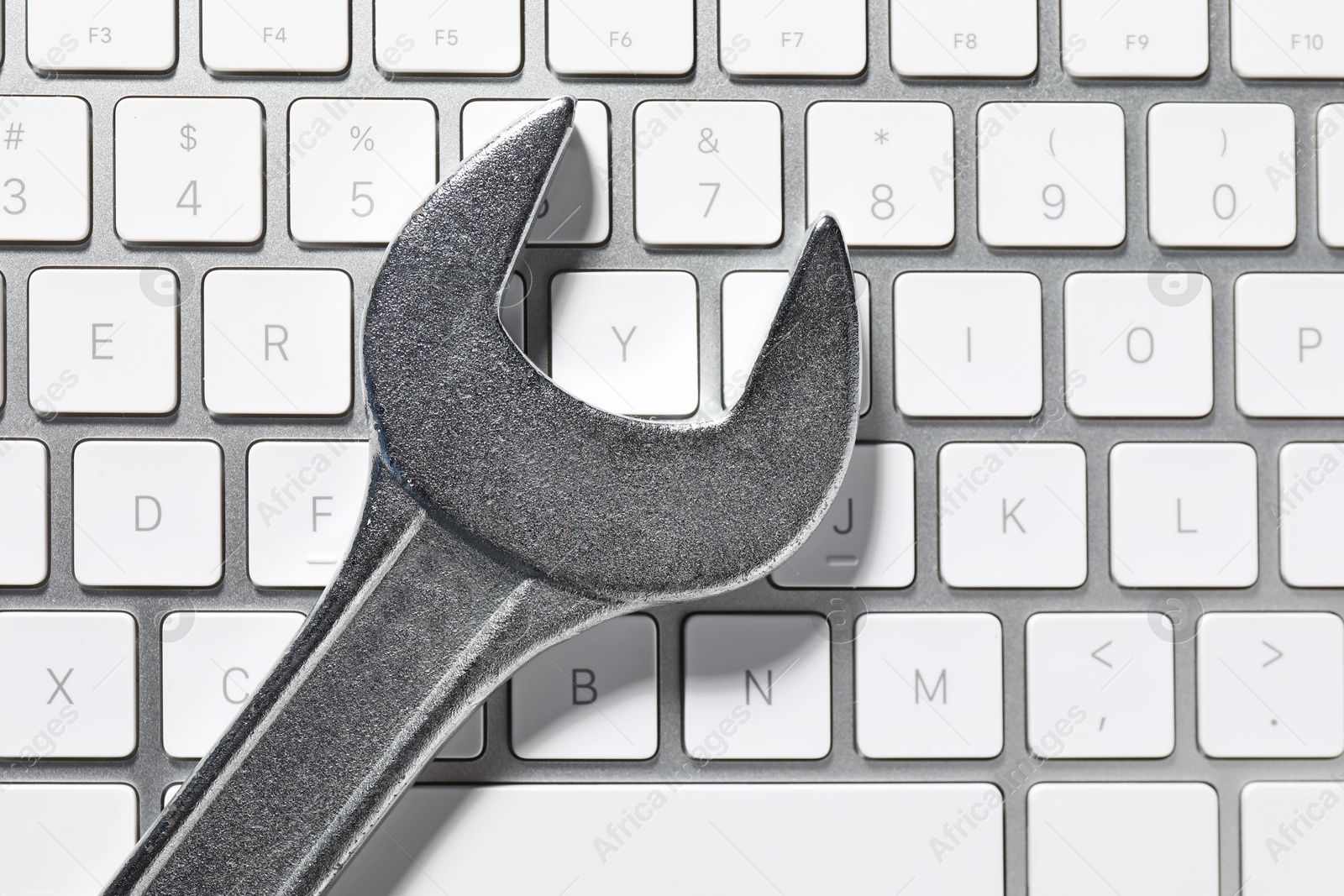 Photo of Technical support concept. Wrench on keyboard, top view