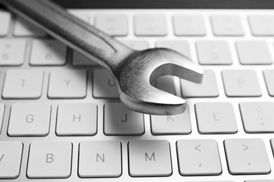 Photo of Technical support concept. Wrench on keyboard, closeup