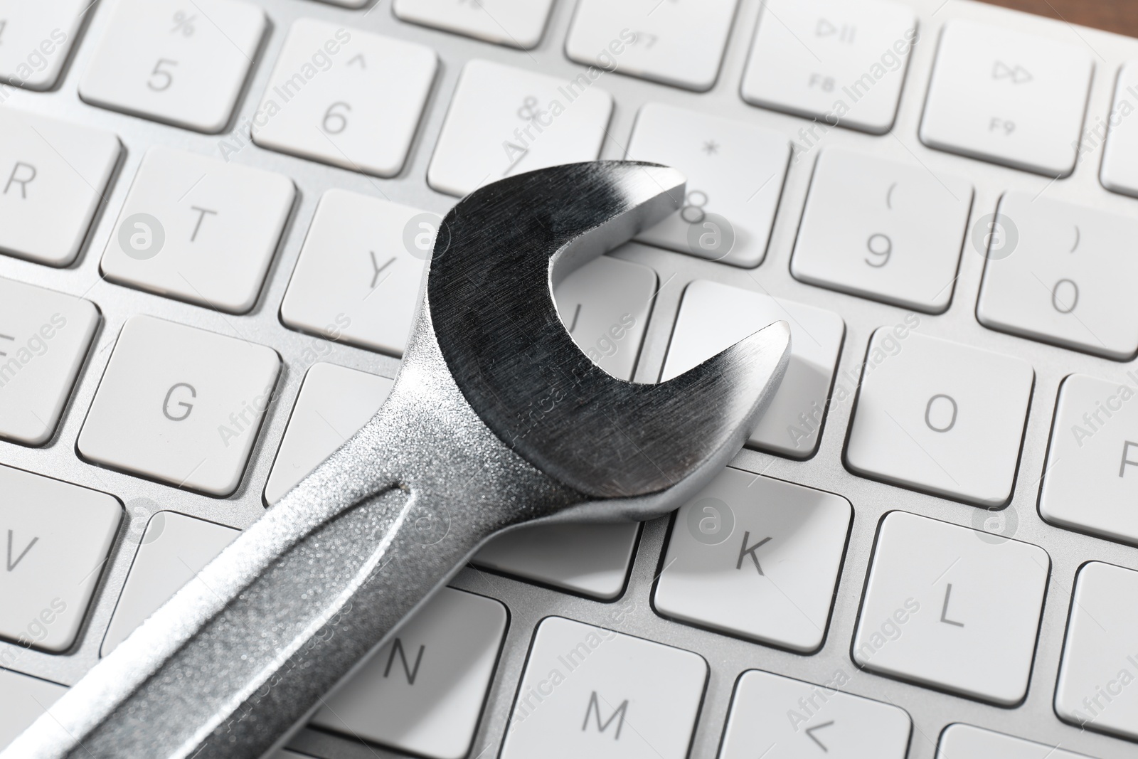 Photo of Technical support concept. Wrench on keyboard, closeup