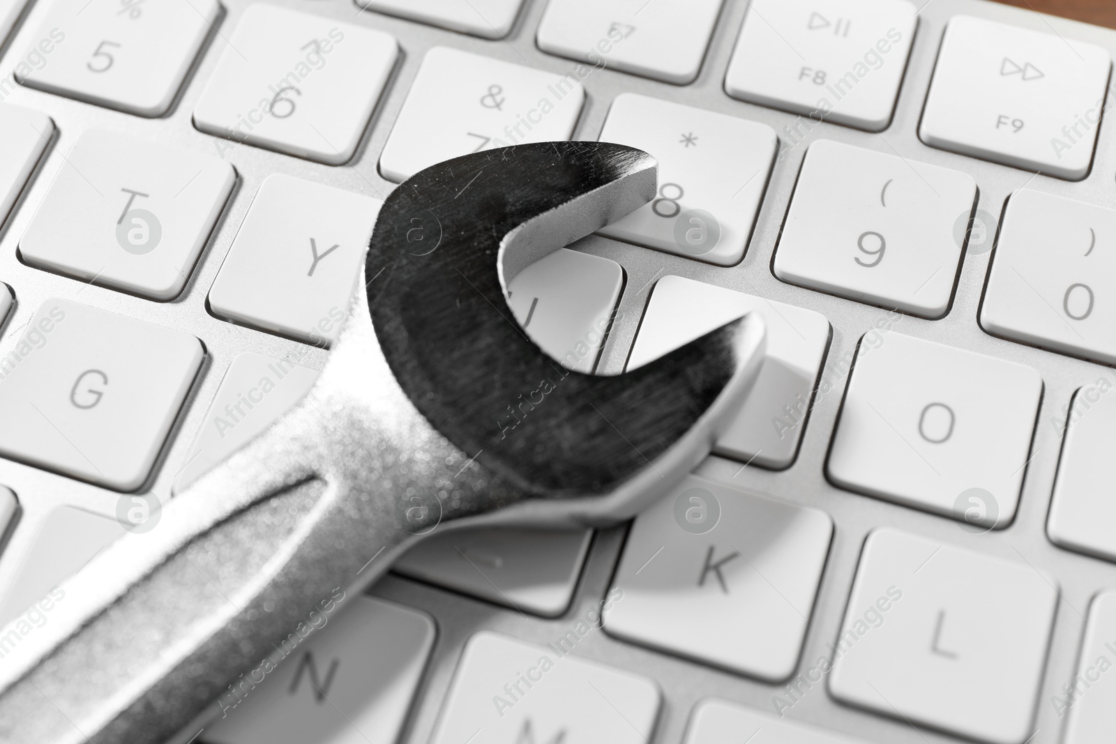 Photo of Technical support concept. Wrench on keyboard, closeup