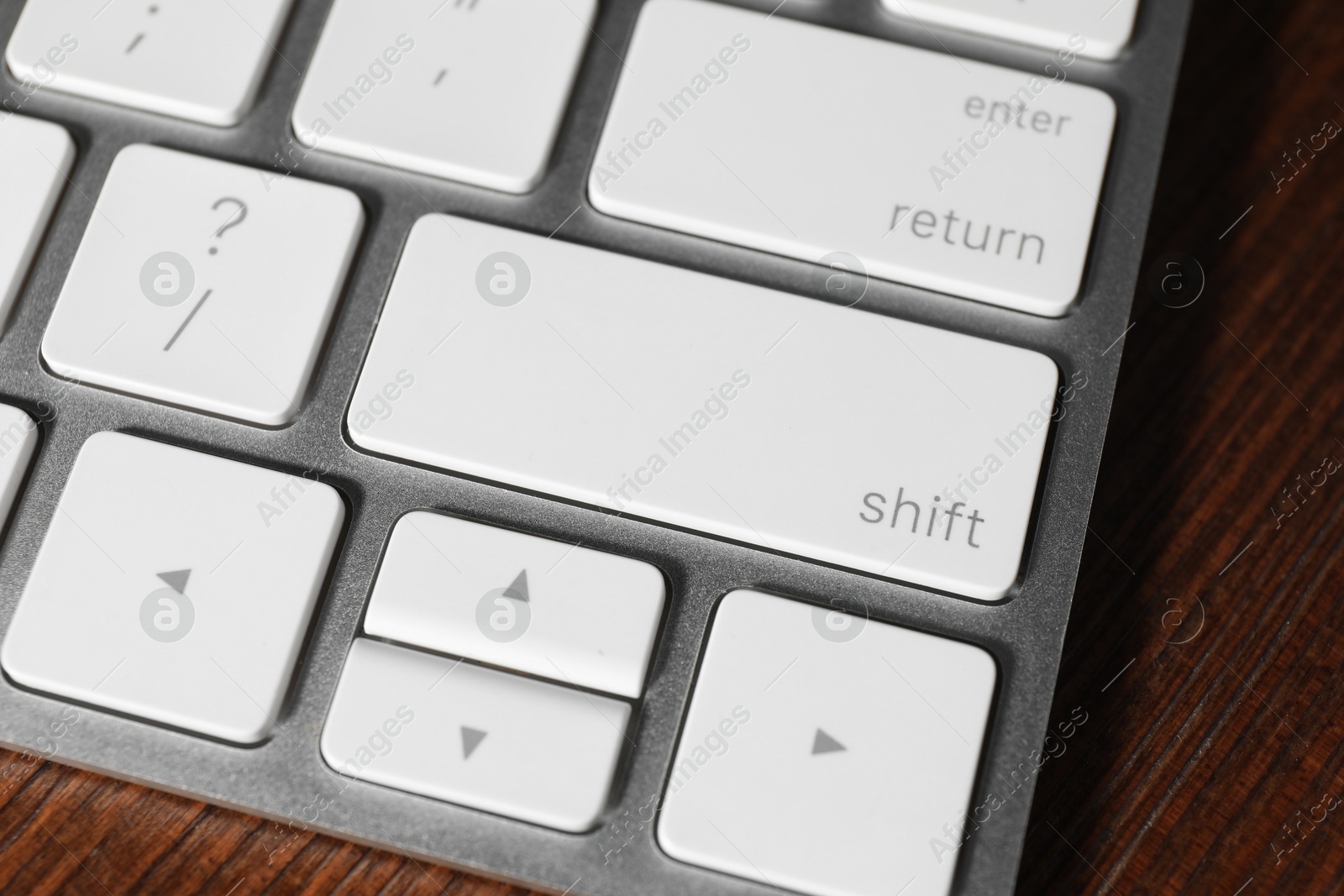 Photo of Technical support concept. Modern keyboard on wooden background, closeup