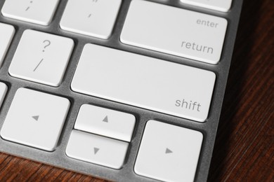 Photo of Technical support concept. Modern keyboard on wooden background, closeup