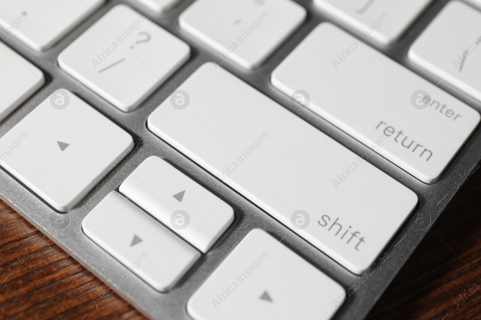 Photo of Technical support concept. Modern keyboard on wooden background, closeup