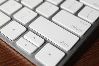 Photo of Technical support concept. Modern keyboard on wooden background, closeup