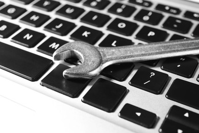 Photo of Technical support concept. Wrench on laptop keyboard, closeup