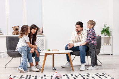 Photo of Overwhelmed parents and their hyperactive children at home