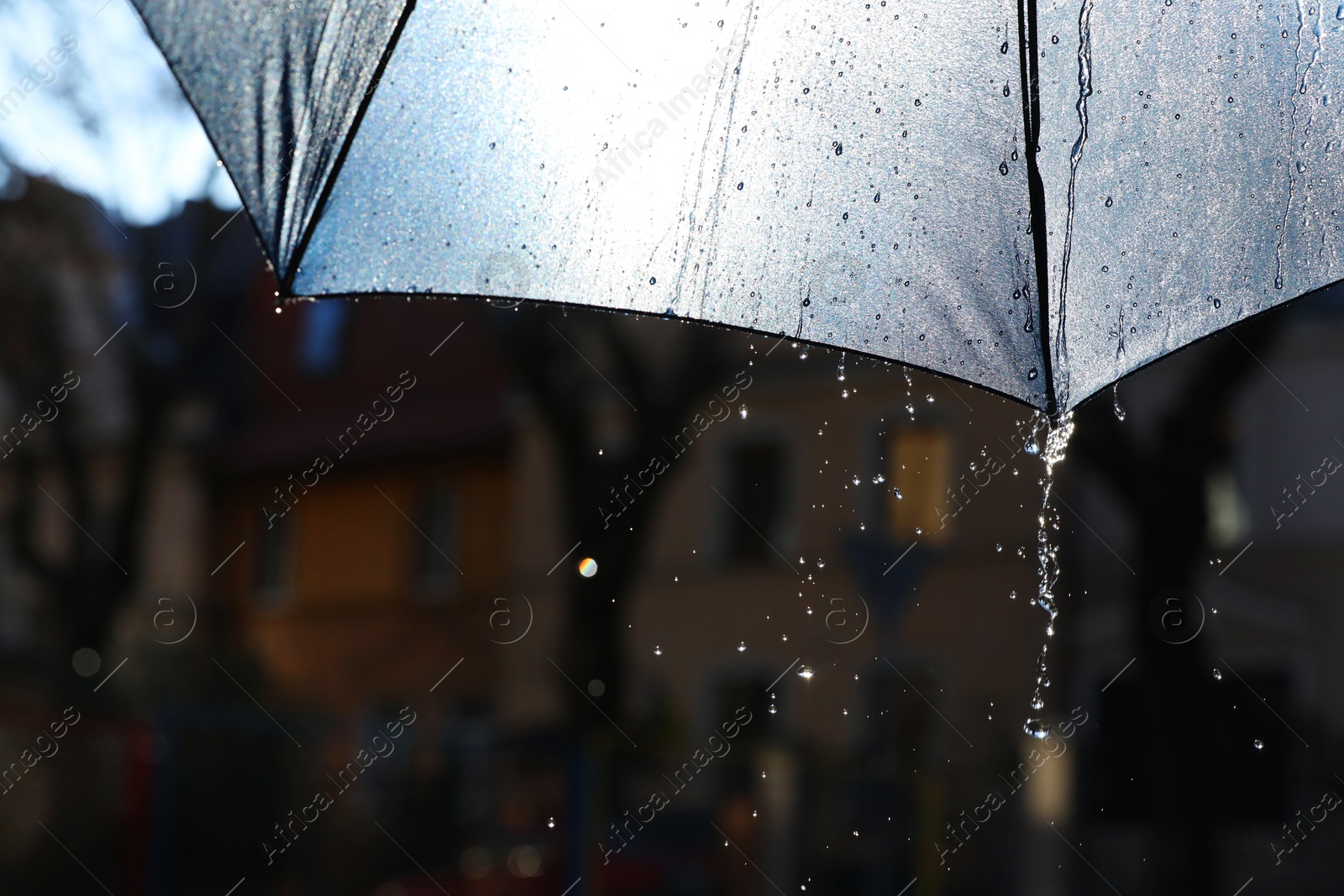 Photo of Open umbrella under pouring rain outdoors, closeup