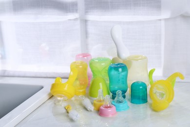 Photo of Clean feeding bottles drying on counter indoors