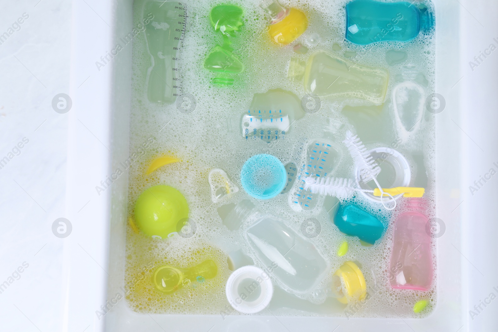 Photo of Washing feeding bottles in sink, top view