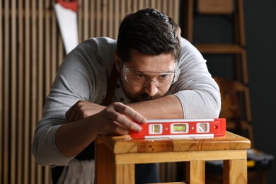 Photo of Professional repairman checking stool level in workshop