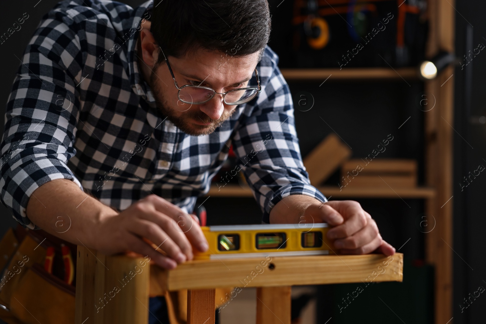 Photo of Professional repairman checking stool level in workshop