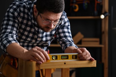 Photo of Professional repairman checking stool level in workshop