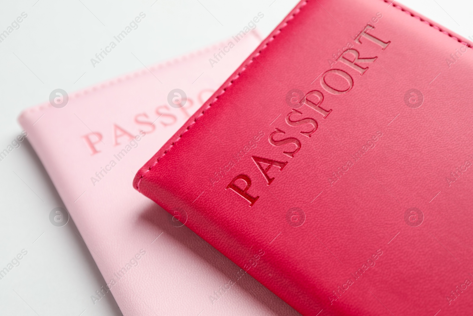 Photo of Passports in color covers on light background, closeup