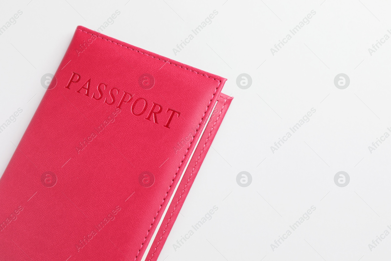 Photo of Passport in red cover on light background, top view. Space for text