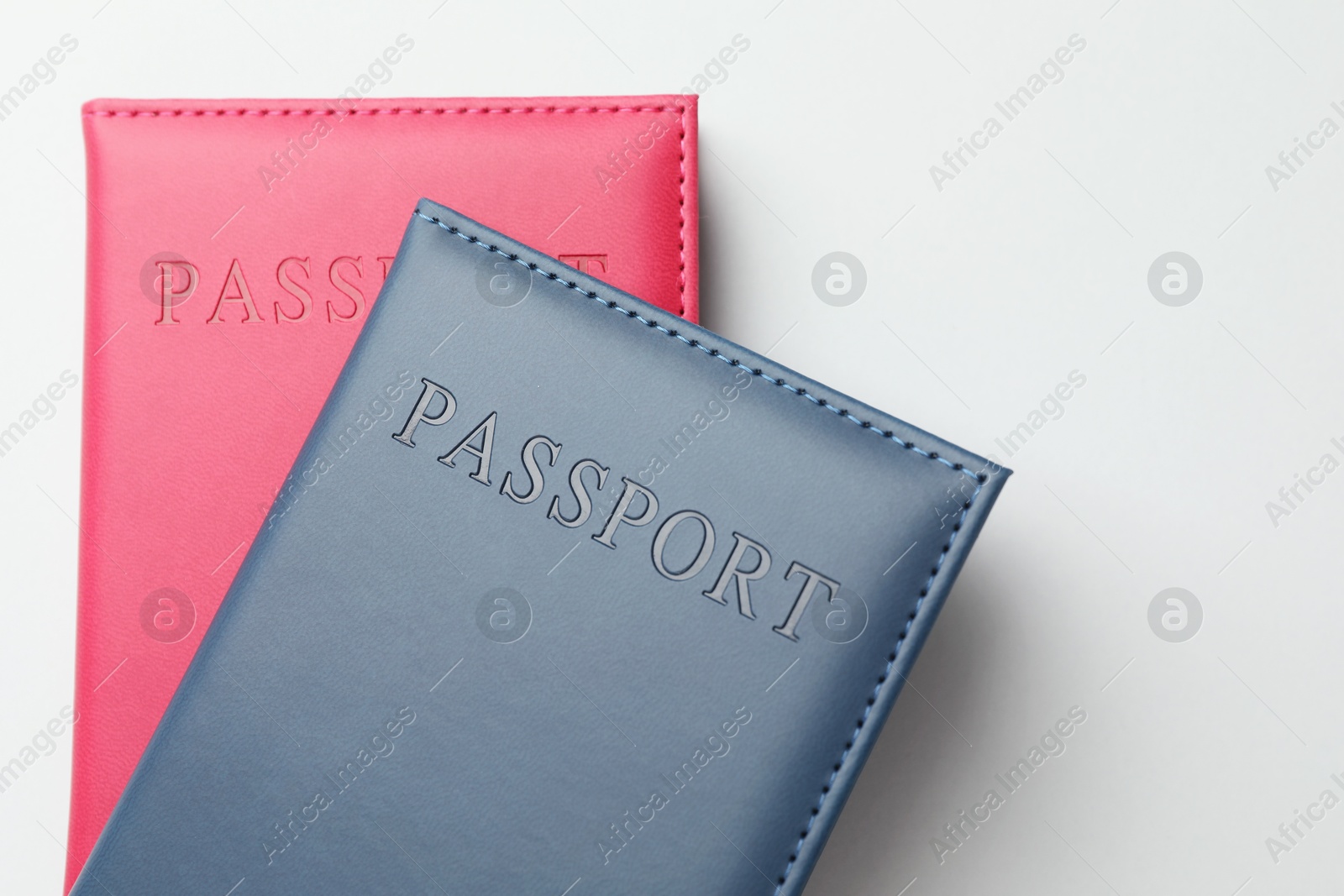 Photo of Passports in color covers on light background, top view