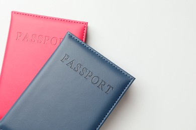 Photo of Passports in color covers on light background, top view. Space for text