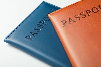 Photo of Passports in color covers on light background, closeup