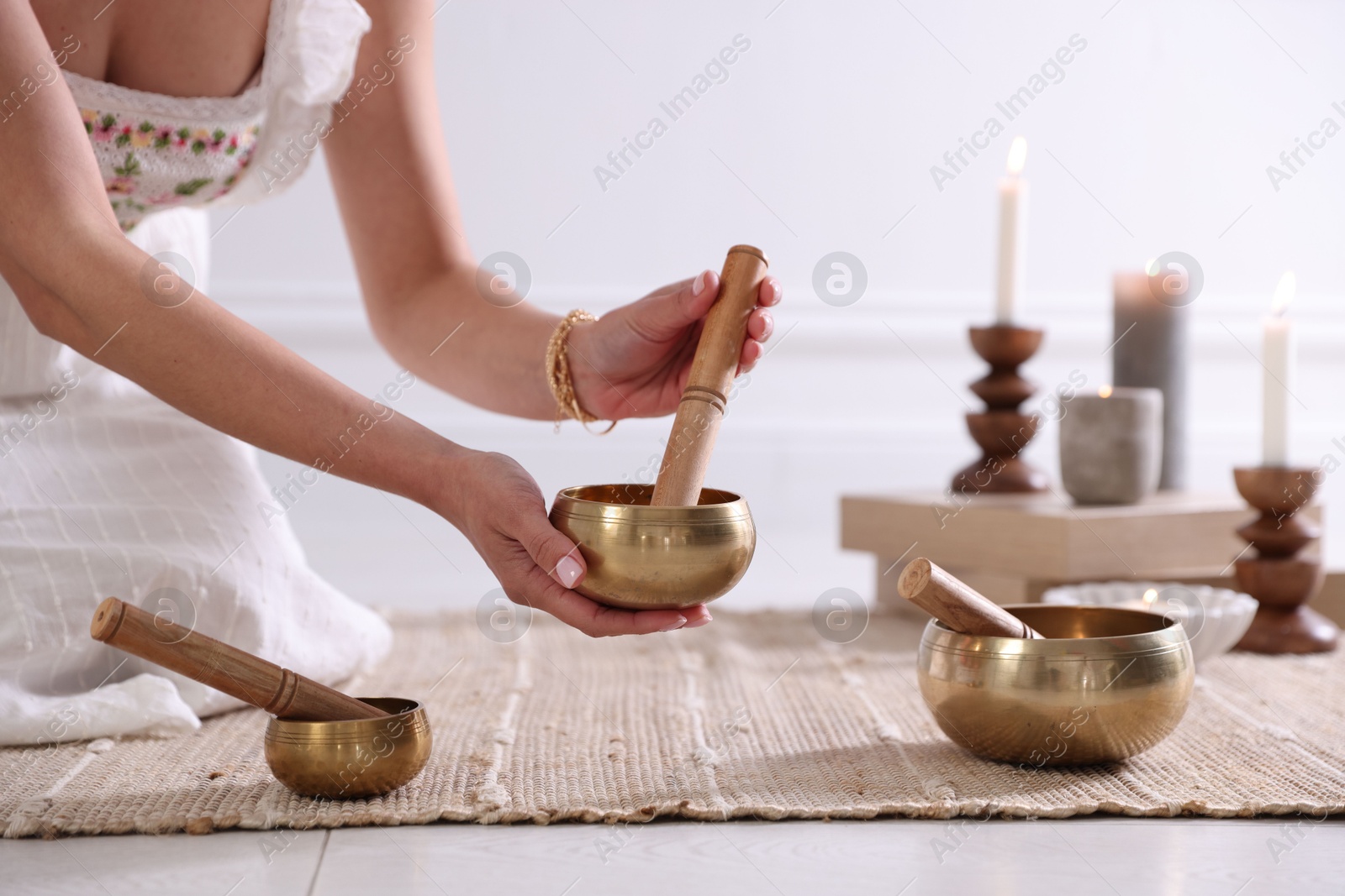 Photo of Woman with singing bowls on floor indoors, closeup