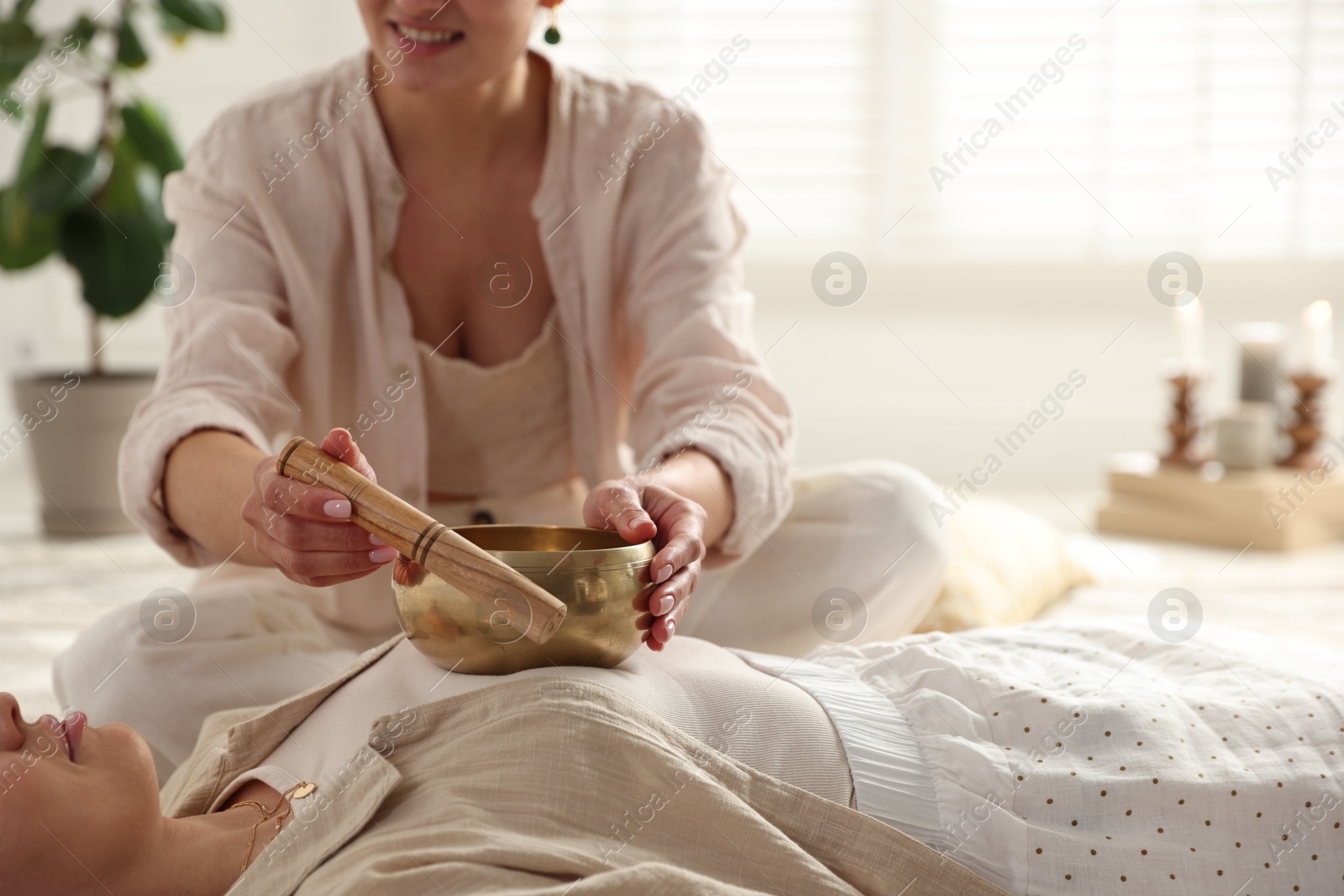 Photo of Woman undergoing singing bowl therapy indoors, closeup