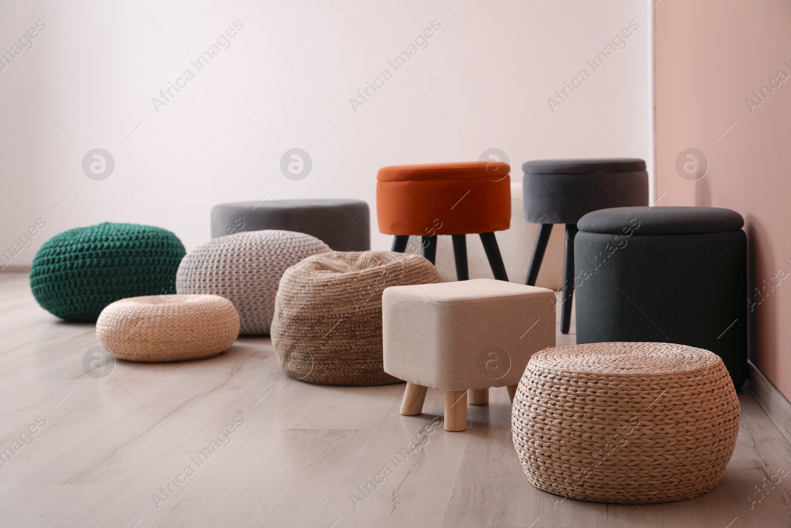 Photo of Different stylish poufs and ottomans in room