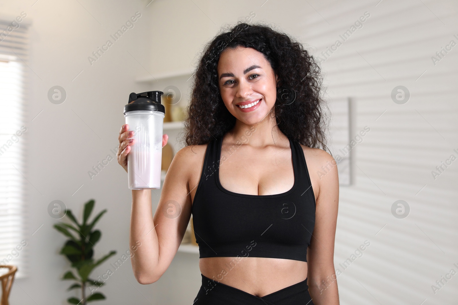 Photo of Beautiful woman with protein shake at home